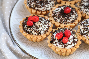 Tiny cupcakes with fruits and chocolate on the table.
