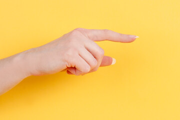 Woman's hand isolated on yellow background.