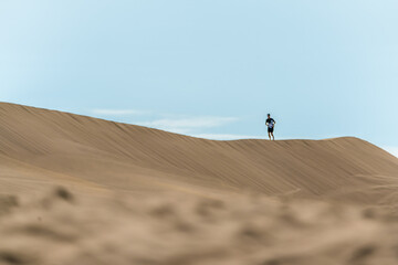 Hiker among sand dunes in the desert. 