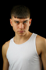 Obraz premium Teenage boy in a white sleeveless top