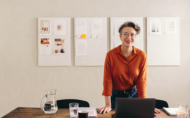 Mature interior designer smiling at the camera in her office