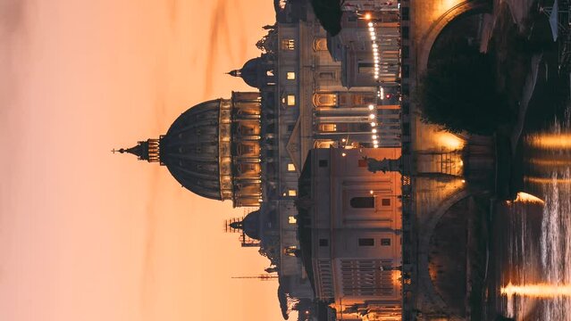 Rome, Italy. Papal Basilica Of St. Peter In The Vatican And Aelian Bridge In Evening Night Illuminations. Vertical Footage Video Day To NIght Time Lapse. Sunset Time.