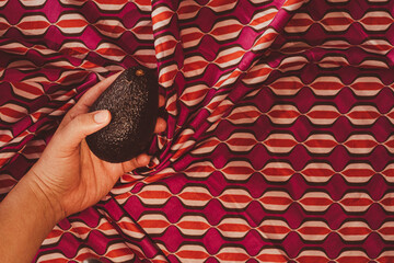 hand holding an avocado on vintage background