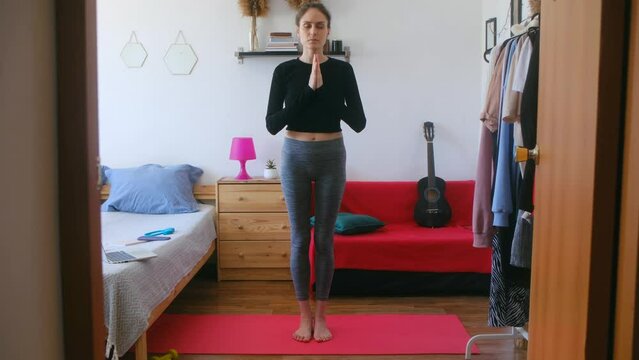 Young Woman Standing with Prayer Hands at Home During the Day. High quality 4k footage. Eka Pada Pranamasana. 