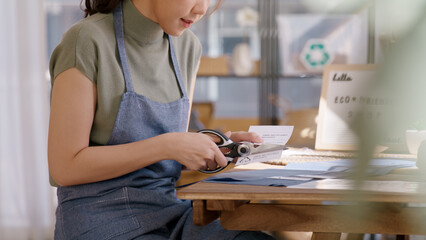 Eco vendor go green packaging parcel carton box in net zero waste store asian seller retail shop. Earth care day small SME owner asia people wrap reuse brown paper pack gift reduce plastic free order.