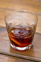 Vertical shot of a glass of alcoholic drink on a wooden surface