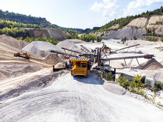 The dump truck unloads the gravel onto the conveyor system.