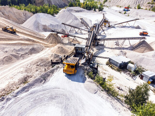 Aerial view of dump truck unloads the gravel onto the conveyor system.
