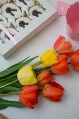 Zelfklevend Fotobehang Closeup view of beautiful tulips next to the chocolate box © Nenad Zivanovic/Wirestock Creators