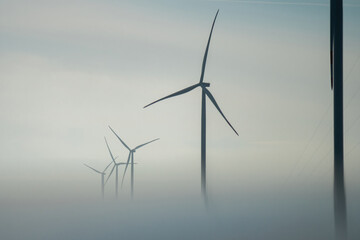 Windmills with rotor blades producing alternative form of energy for buildings and stations. Wind...