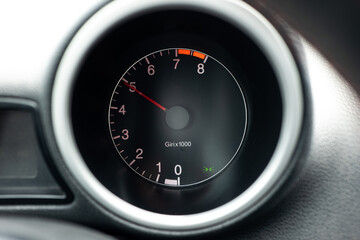 Car engine rev meter or tachometer showing 5000 rpm . Close up shot, no people