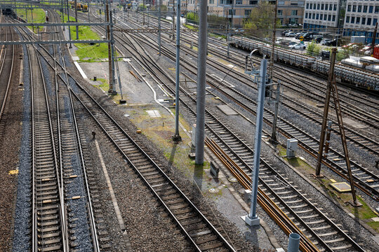 Several empty parallel train tracks in major rail hub in European city. Above view, trains, no people