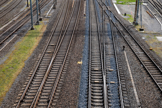 Several empty parallel train tracks in major rail hub in European city. Above view, trains, no people