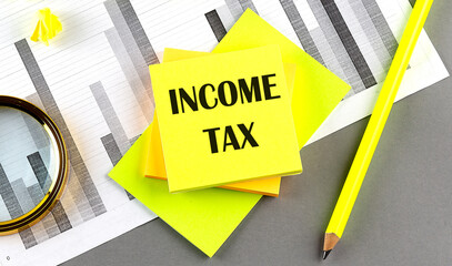INCOME TAX text on sticky on sticky on chart with pen