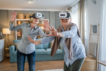 two Women mature senior females at home use virtual reality VR headset