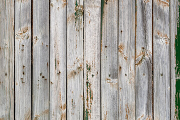 Old rustic wooden wall with scraps of worn out paint
