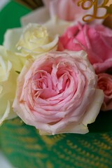 Vertical closeup of a green cake decorated with pink roses