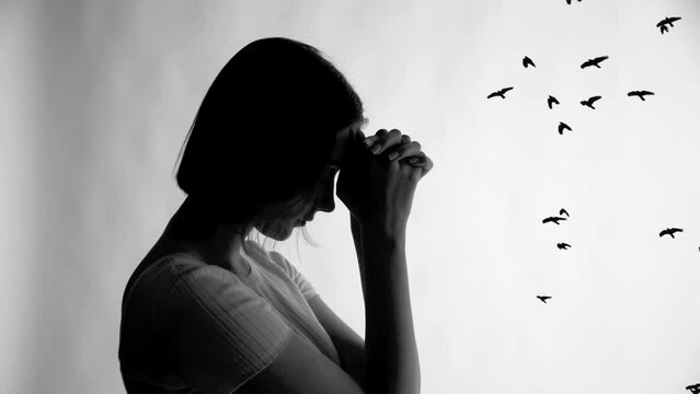 Portrait of a sad young woman on a white background over which black silhouettes of birds fly. Cg