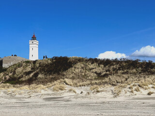Fototapeta na wymiar Leuchtturm und Dünen in Blaavand Dänemark 