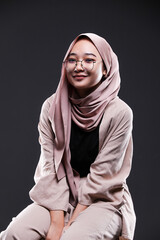 Cute young Asian hijab corporate girl with smooth glowing skin smiling and relaxing over an isolated background studio. Beauty skin care, office concept.