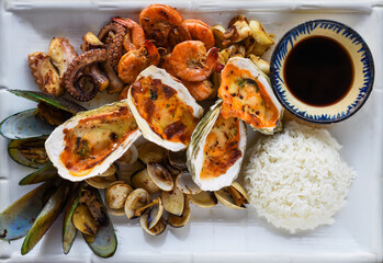 Sauteed seafood on white plate close up isolated on black background top view