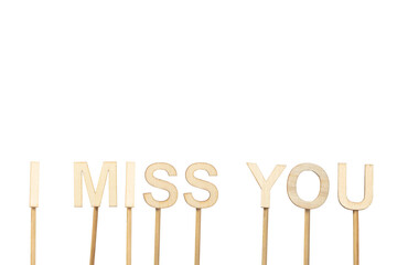 I miss you sign made with individual wooden letters on a green chroma background.