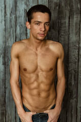 Young attractive guy with a beautiful body posing in the studio.