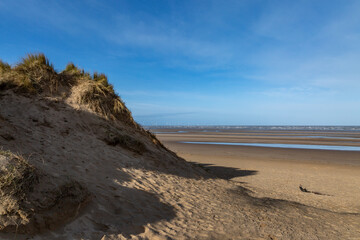 Fototapeta na wymiar Blue sky over the sand dunes and vast sandy beach at Formby, in Merseyside