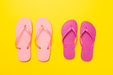 Many bright flip flops on color background, top view