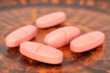Several medical pills on a clay dish, macro.
