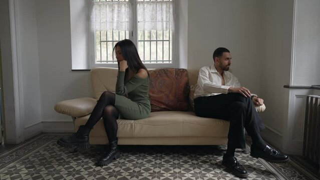 Alienated couple on the brink of separation. Young man and woman giving each other the silent treatment during relationship crisis