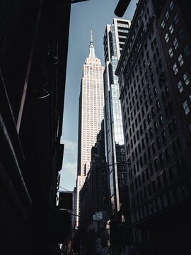 Vertical shot of buildings with the background of the Empire State Building in of New York