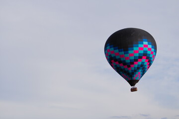 Balão de ar quente preto voando em um dia de sol 