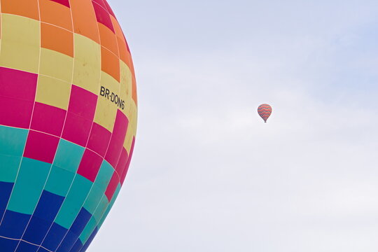 Balão de ar quente colorido voando pelo céu azul