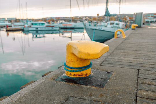 Old rusty iron yellow mooring bollard at sea. Sopot, Poland