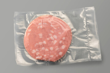 Slices of Mortadella in vacuum sealed package for sous vide cooking isolated on gray © framarzo