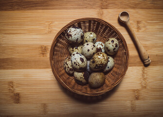 Obraz na płótnie Canvas Quail eggs in a wicker basket wooden chopping board background.Food and drink .