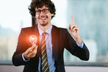 Businessman holding light bulb. Idea concept with innovation and inspiration.  businessman holding illuminated light bulb. Brain creative thinking ideas and innovation concept.