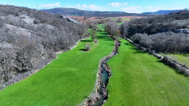 Meanders in the Lucio River in Renedo de la Inera. Aerial view from a drone. Recuevas Valley. World geological heritage UNESCO. Las Loras Geopark. Palencia. Castile and Leon. Spain, Europe