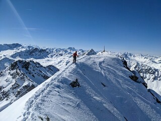 Fototapeta na wymiar Ski mountaineering on the Fluela Wisshorn in Davos. Ski tour in Grisons mountains with fantastic view. Summit ridge.