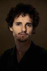 A portrait of a man lit by a ray of light.