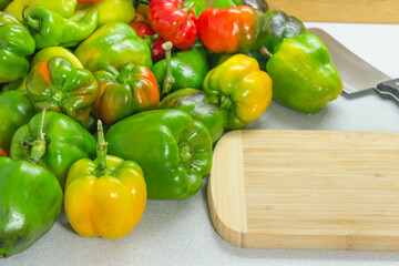 Prepared sweet peppers for cooking on the table next to a cutting board and a knife