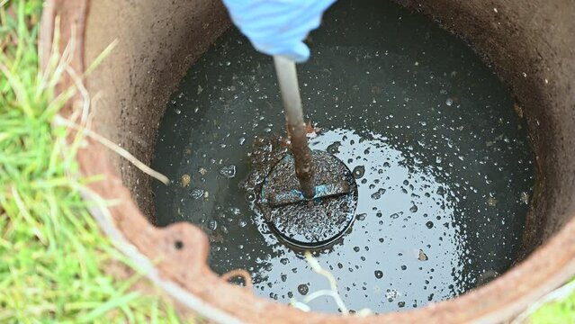 Video of a working plumber opening a septic system tank and removing the filter