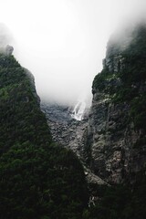 Vertical shot of cliffs in Western Brook Pond with fog