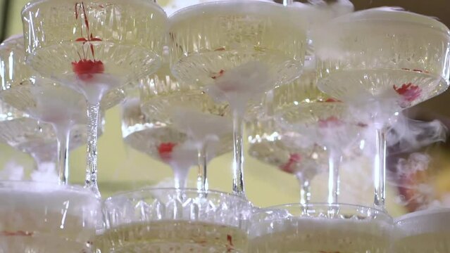 Tower of glasses at celebration party. Welcome drinks, tower of champagne or sparkling wine. Empty with red berry. Restaurant ready for reception. Alcoholic beverage.