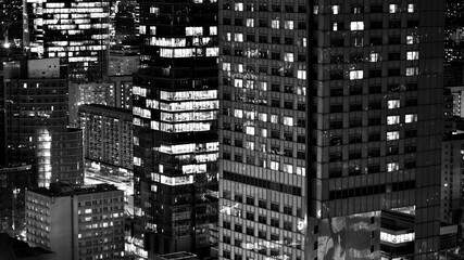 Fototapeta na wymiar View of at night glass buildings and modern business skyscrapers,. View of modern skyscrapers and business buildings in downtown. Big city at night. Black and white.