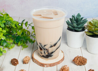 frozen milk with grass jelly served om disposable glass isolated on wooden board top view of hong kong drink