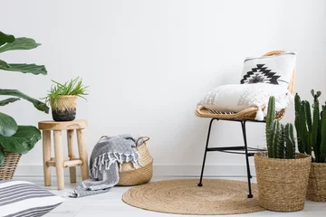 Fototapete Boho decor in boho style in room with chair, cushions and houseplants  © brizmaker