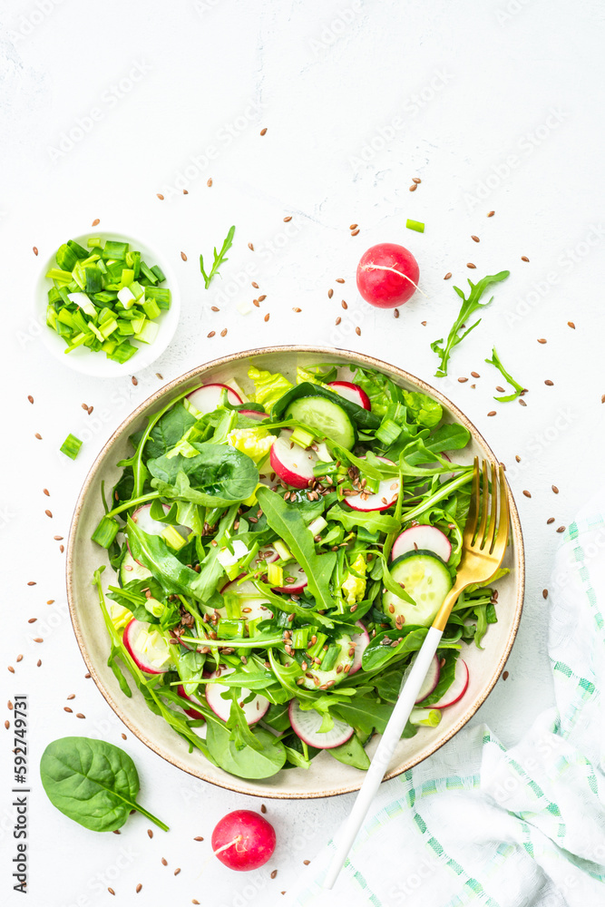 Sticker Green salad with spinach, arugula and radish with olive oil on white table. Top view with copy space.