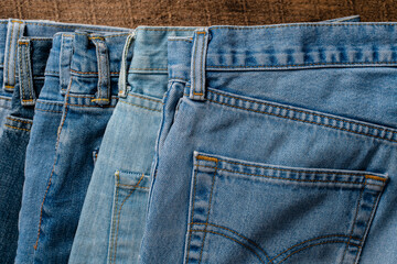 Lots of jeans pants, closeup. Denim background. The concept of buying, selling, shopping and trendy modern clothes